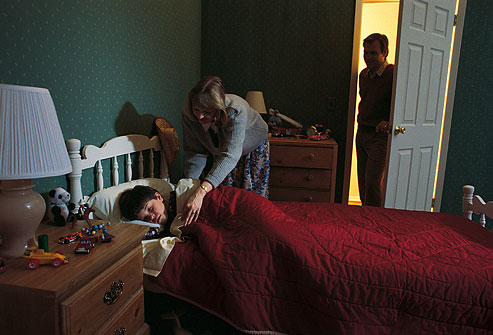 getty_rf_photo_of_mother_tucking_son_into_pleasant_bed.jpg