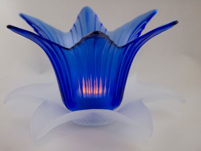 lighted blue and white lotus flower glass candle holder in a white background.jpg