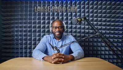 Firefly Male radio announcer, 40 years old, wearing glasses, sitting in a reporting station at a tabnn.jpg