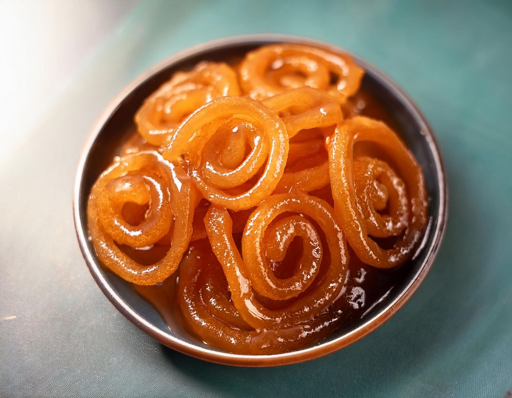 Firefly a vibrant and appetizing image of freshly made jalebi. Golden orang, crispy, with intricate,.jpg